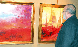 Un visitante de la exposición observa un lienzo.